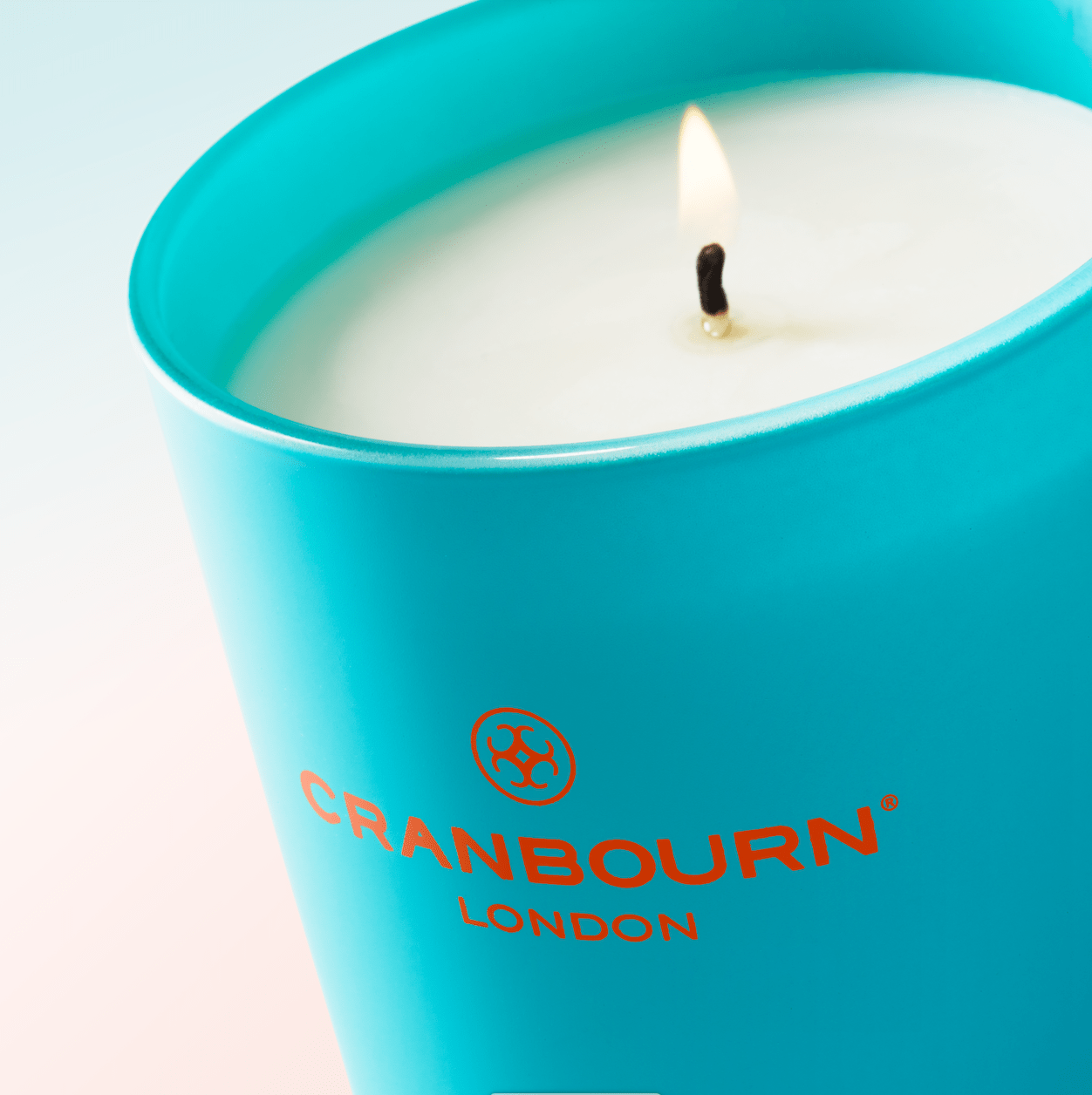 Cranbourn London lit blue glass candle.
