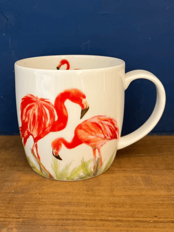 Mug with flamingo design on a wooden surface and blue background