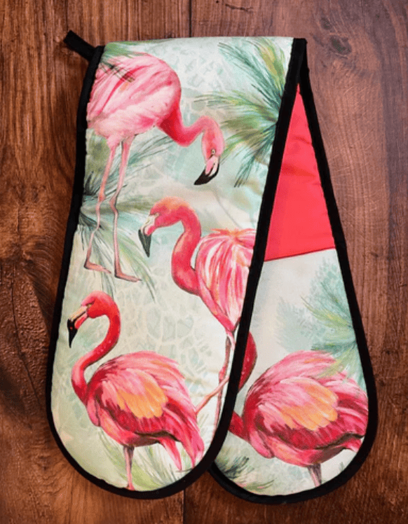 Pair of oven mitts with flamingo design on a wooden surface