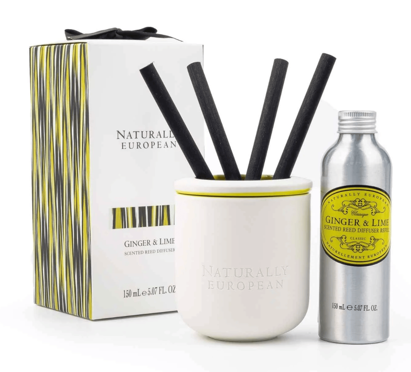 Naturally European Ginger & Lime scented reed diffuser set, featuring a white ceramic diffuser cup with black reeds, a silver atomizer bottle, and the branded product box on a white background.