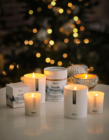 Aery candles and packaging on a table with a blurred Christmas tree in the background