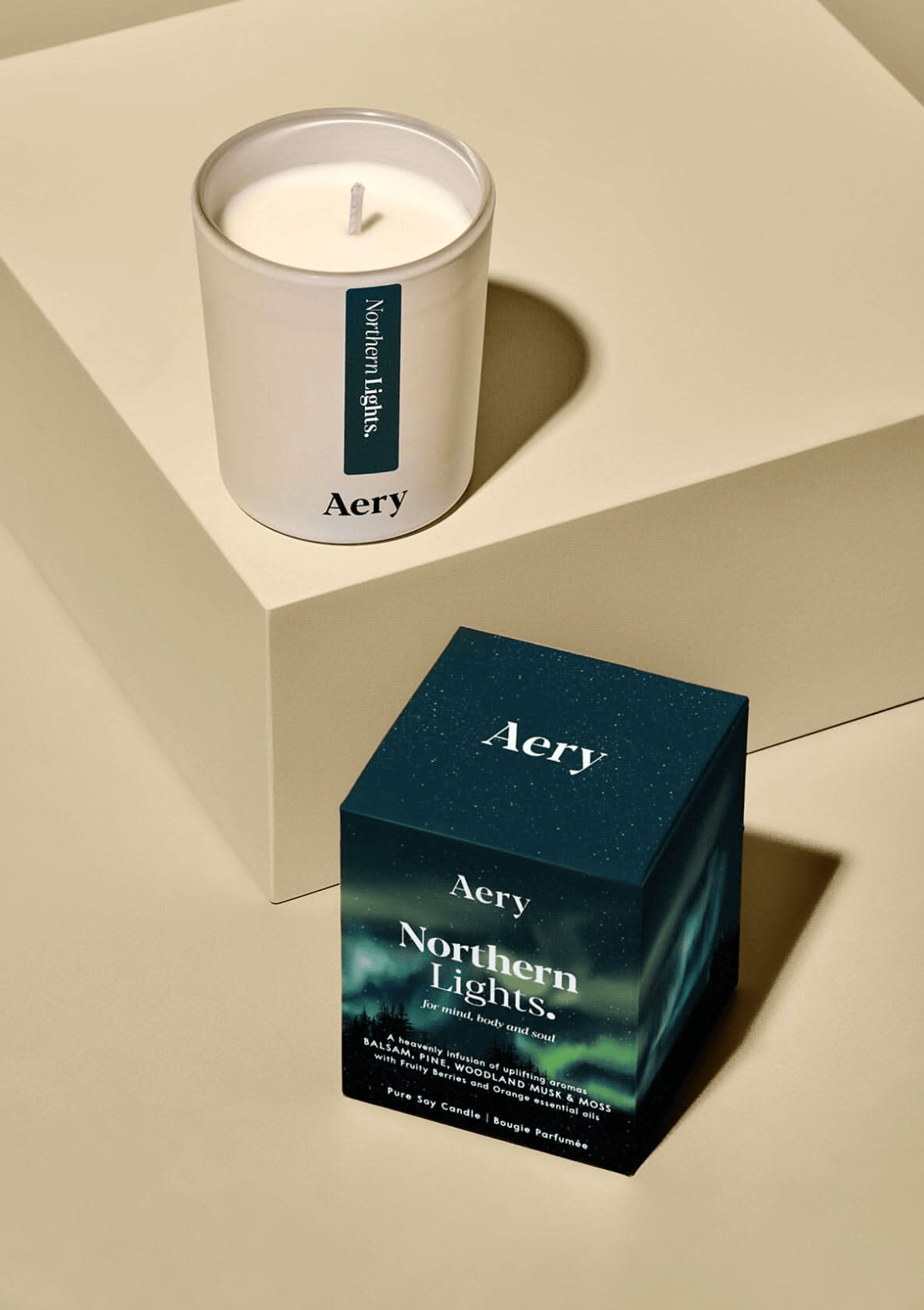 Aery candle and its packaging on a beige surface