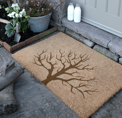 Doormat with tree design on a stone pathway
