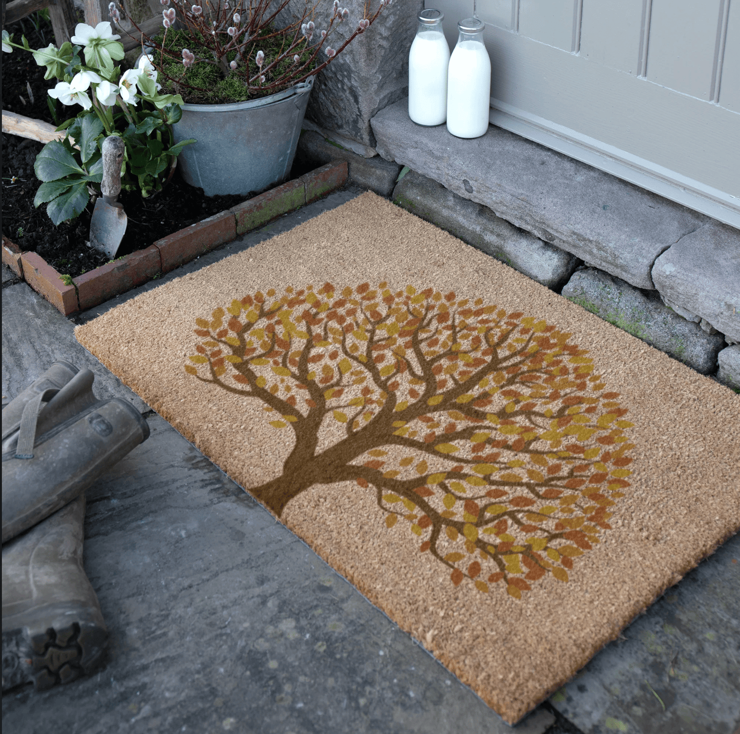 Doormat with autumn tree design on a stone porch