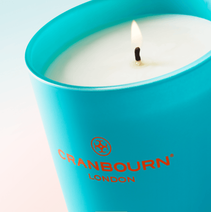 Cranbourn London lit blue glass candle. 