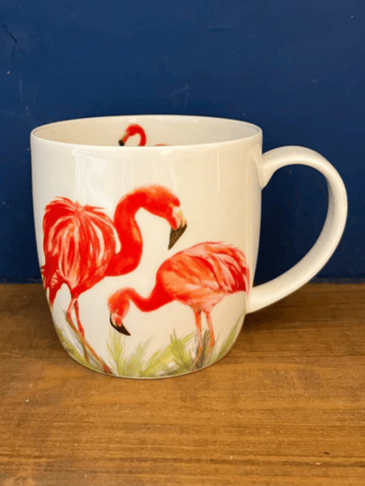 Mug with flamingo design on a wooden surface and blue background