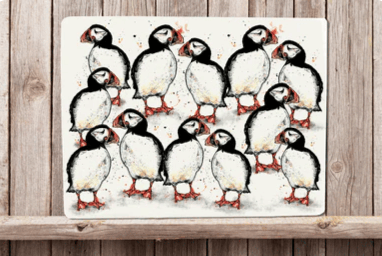 Placemat with a design of puffins on a wooden surface