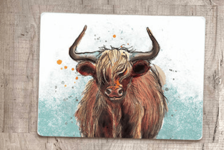 Placemat with a highland cow illustration on a wooden surface