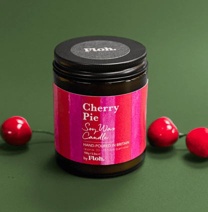 Jar of cherry pie scented candle with a pink label on a green background