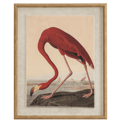 Framed artwork of a red flamingo on a rock with a beige background
