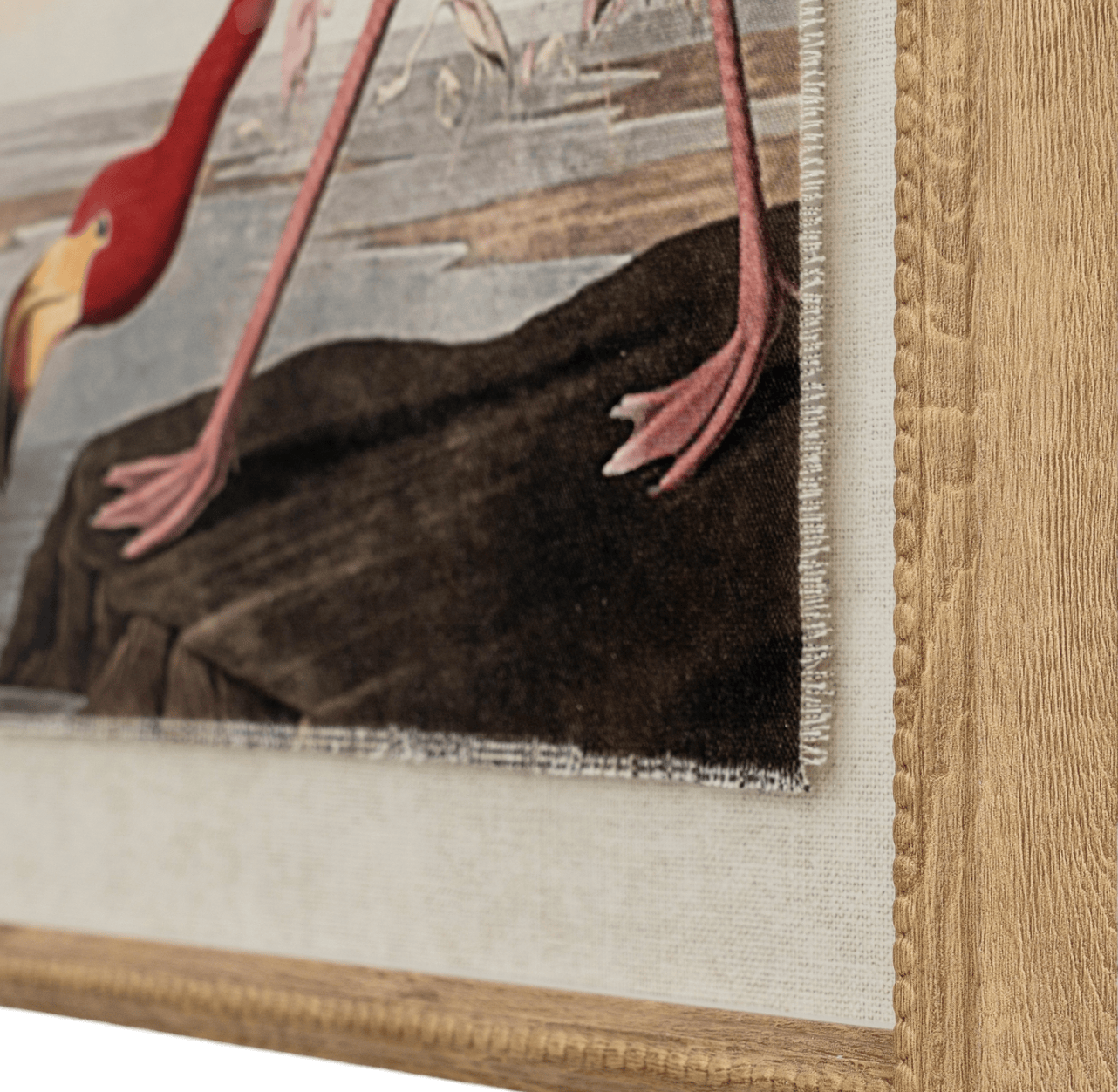 Close-up of a framed painting of a bird with a detailed wooden frame.