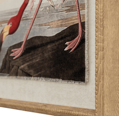 Close-up of a framed painting of a bird with a detailed wooden frame.