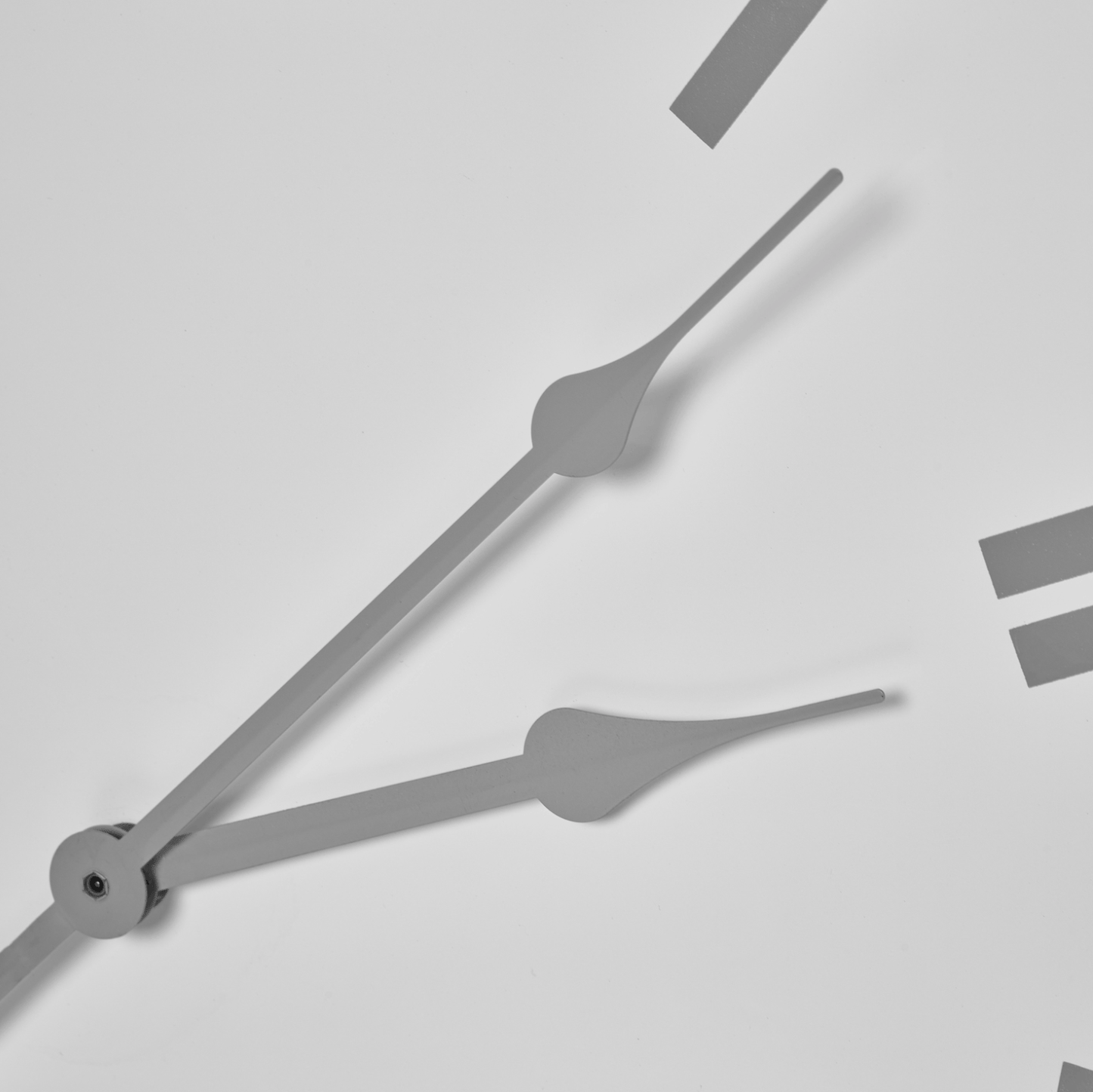 Close-up of a clock with gray hands on a light gray background