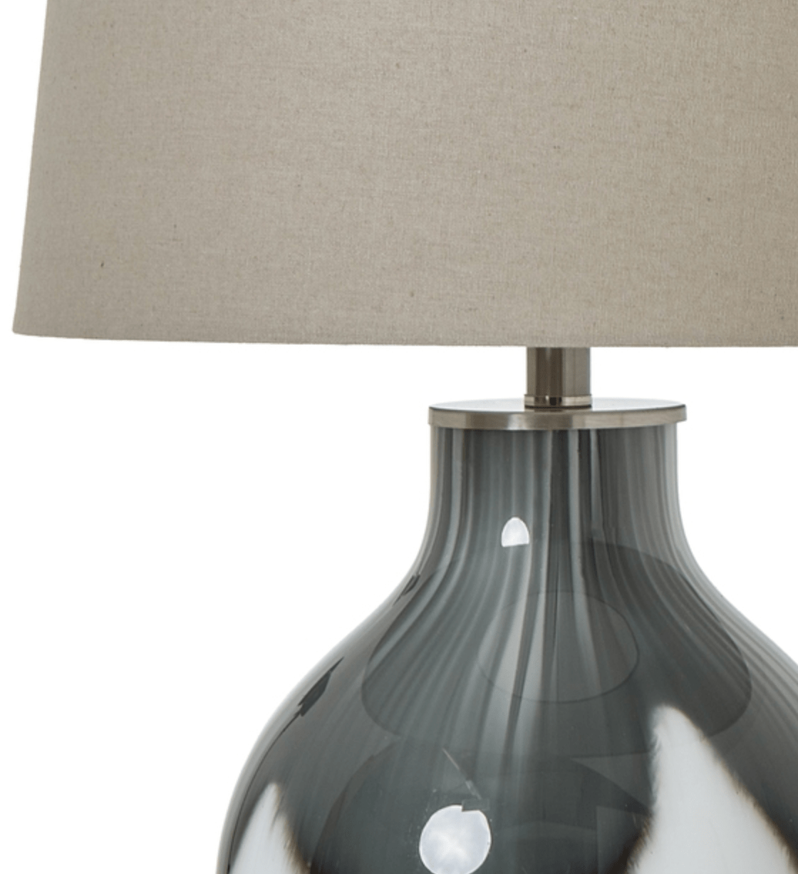 Table lamp with a gray ribbed base and beige lampshade on a white background