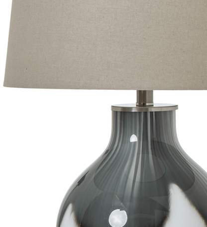 Table lamp with a gray ribbed base and beige lampshade on a white background