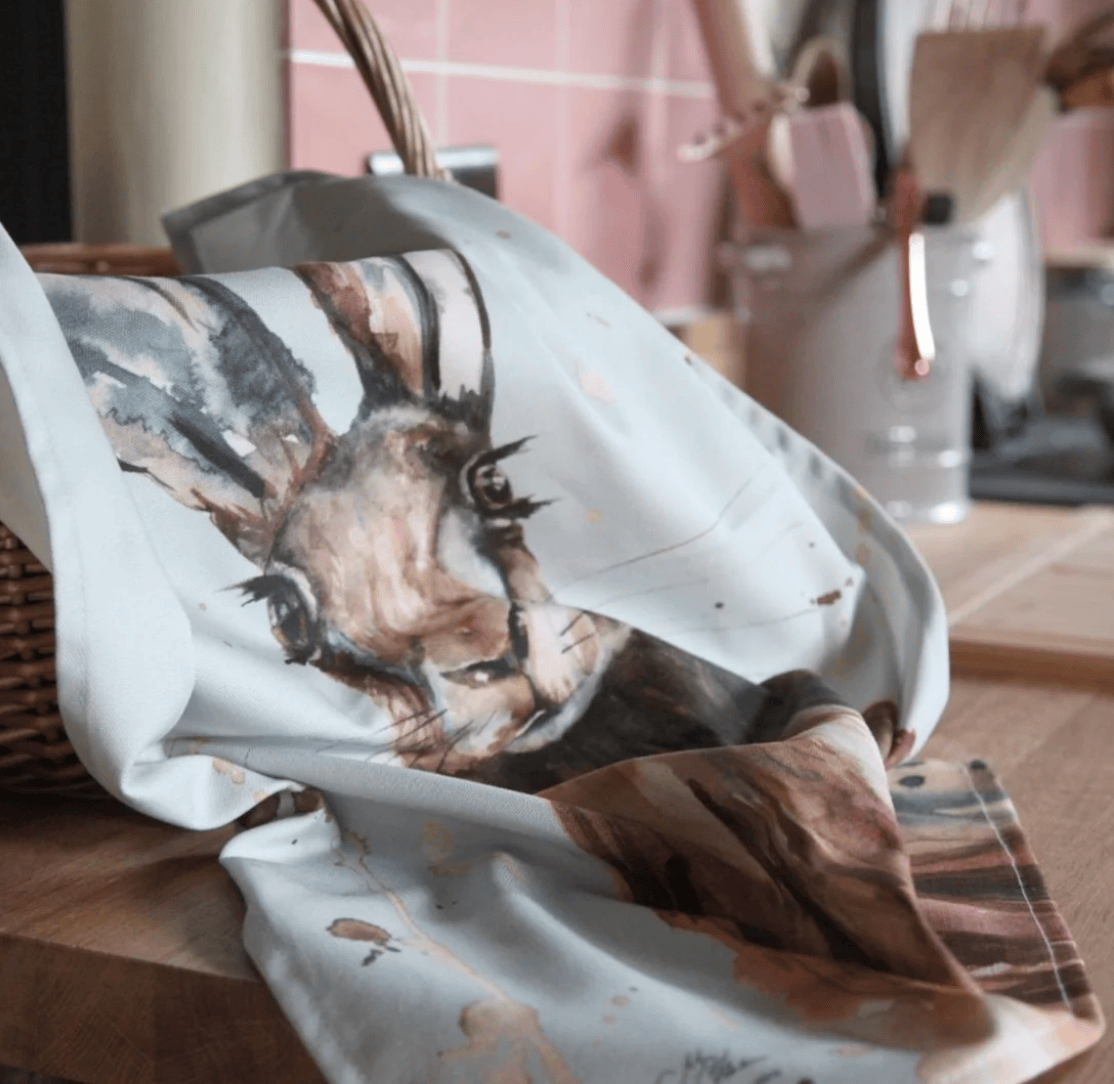 Fabric with a Hare design draped over a surface in a home setting