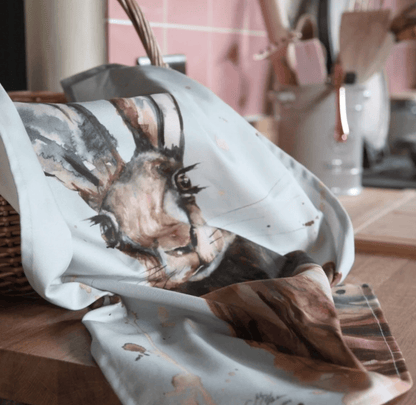 Fabric with a Hare design draped over a surface in a home setting