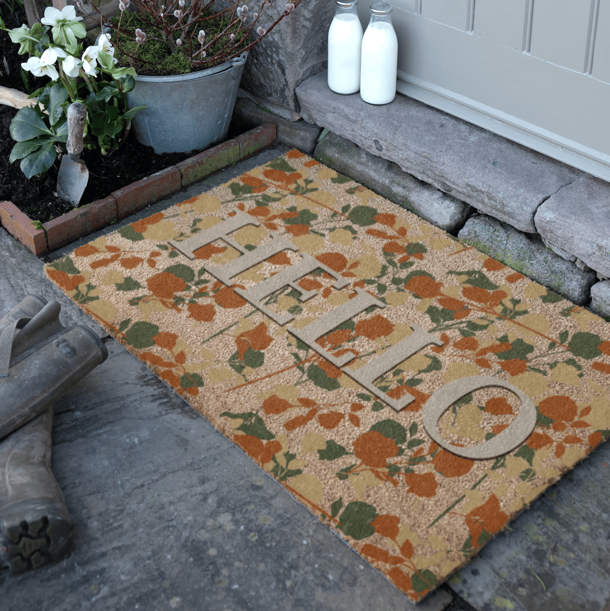 Decorative doormat with floral pattern on a stone pathway