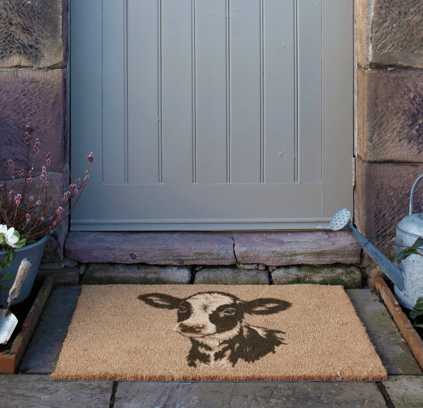 Doormat with a cow design in front of a door