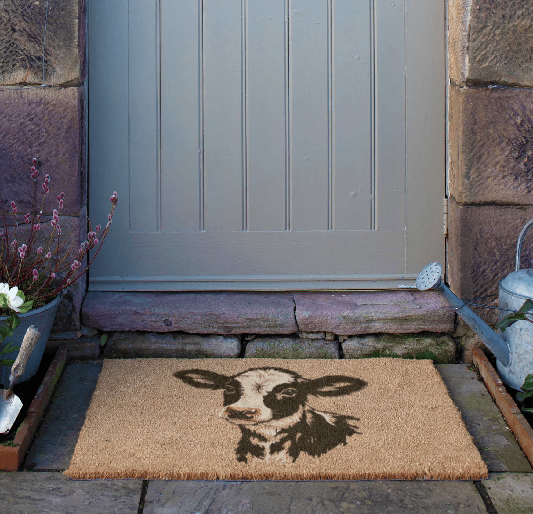 Doormat with a cow design in front of a door