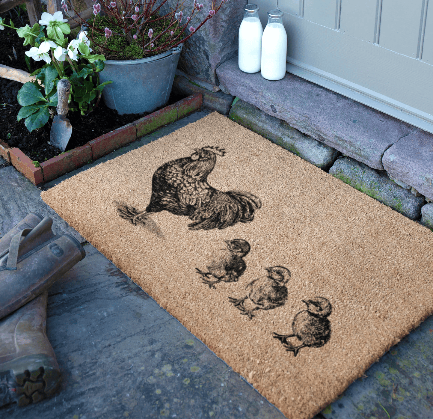 Doormat with hen and chicks design on a stone step.