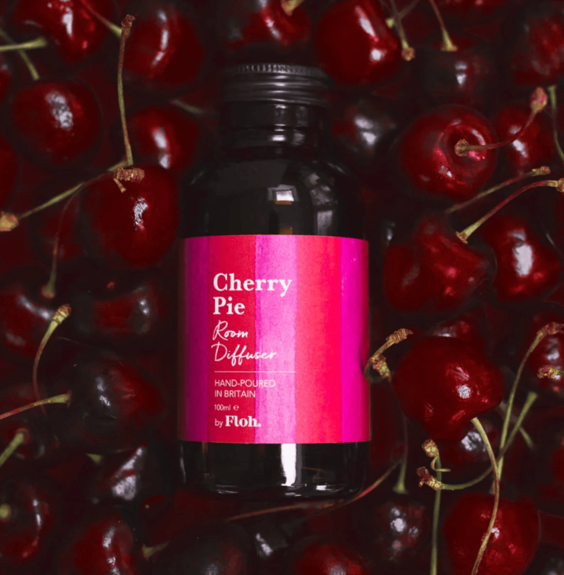 Bottle of 'Cherry Pie' diffuser surrounded by cherries with a pink label.