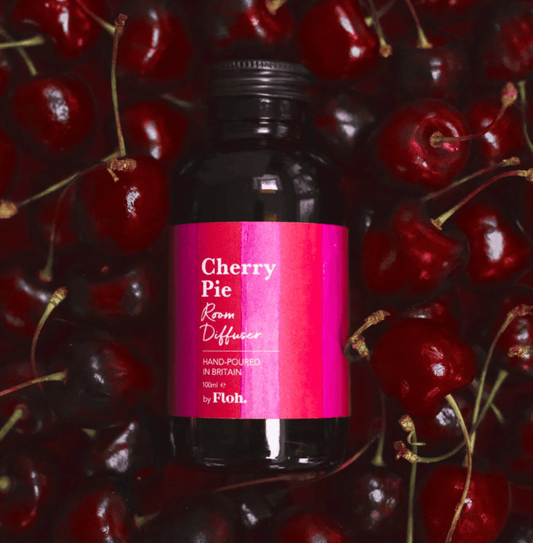 Bottle of 'Cherry Pie' diffuser surrounded by cherries with a pink label.