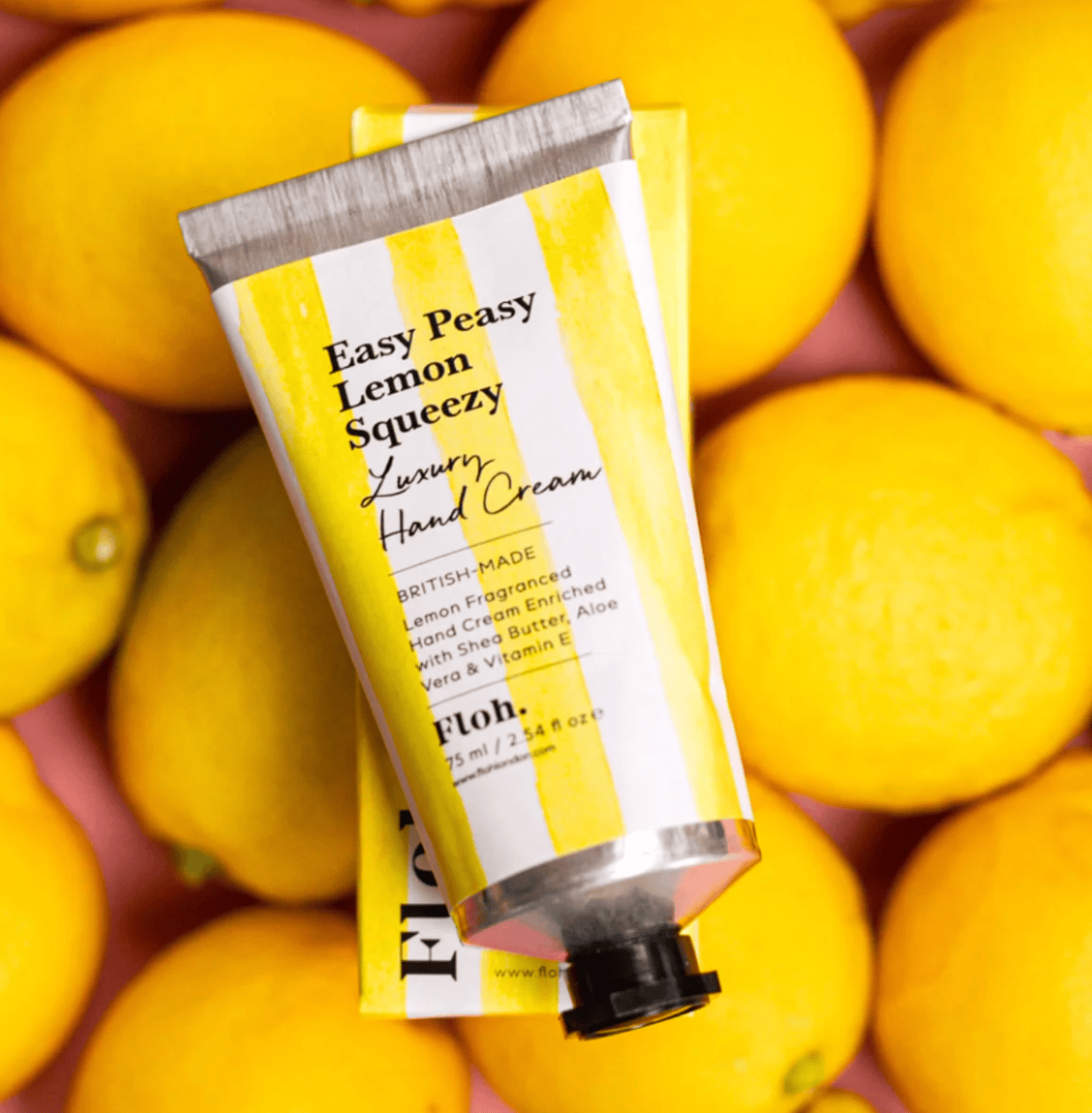 Hand cream tube labeled 'Easy Peasy Lemon Squeezy' on a background of lemons