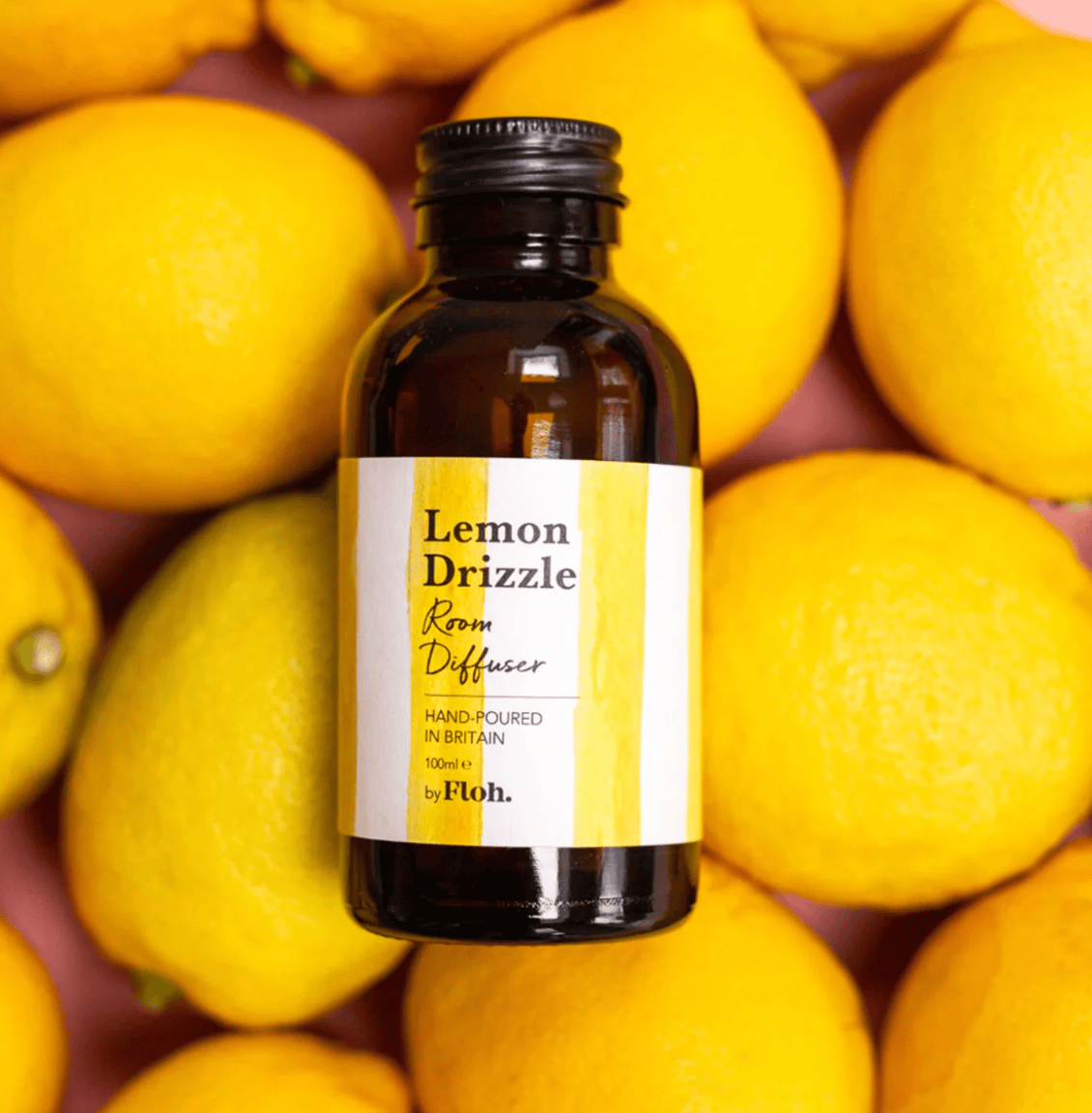 Room diffuser bottle labeled 'Lemon Drizzle' surrounded by lemons