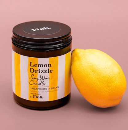 Jar of 'Lemon Drizzle' candle by Floh with a lemon on a pink background