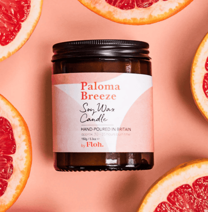 Paloma Breeze soy wax candle with grapefruit slices on a pink background