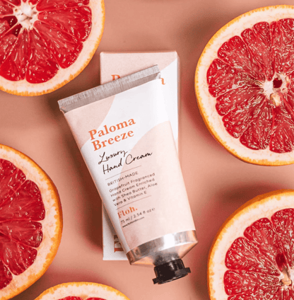 Hand cream with 'Paloma Breeze' branding surrounded by sliced grapefruits on a beige background