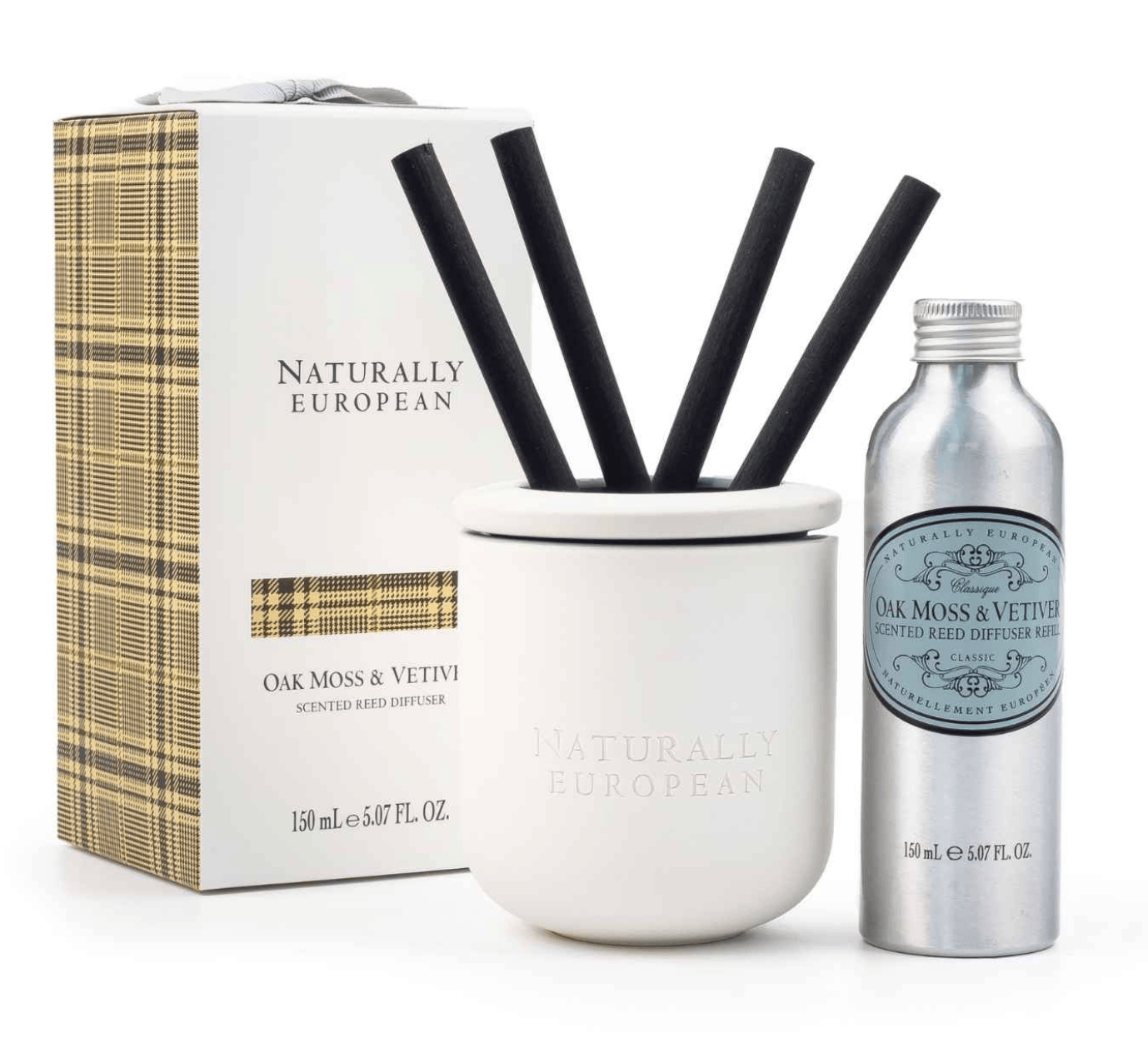 Naturally European Oak Moss & Vettvi scented reed diffuser set, featuring a white ceramic diffuser jar with four black reeds, a silver metal bottle, and the branded packaging box with a beige plaid pattern.