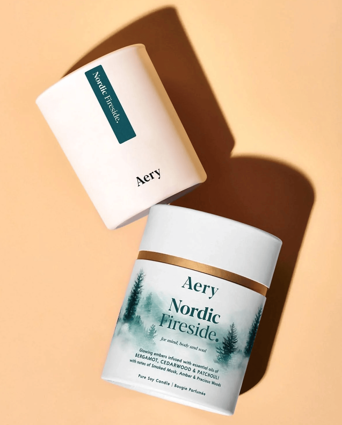 Two Aery candles, one open and one closed, on a beige background