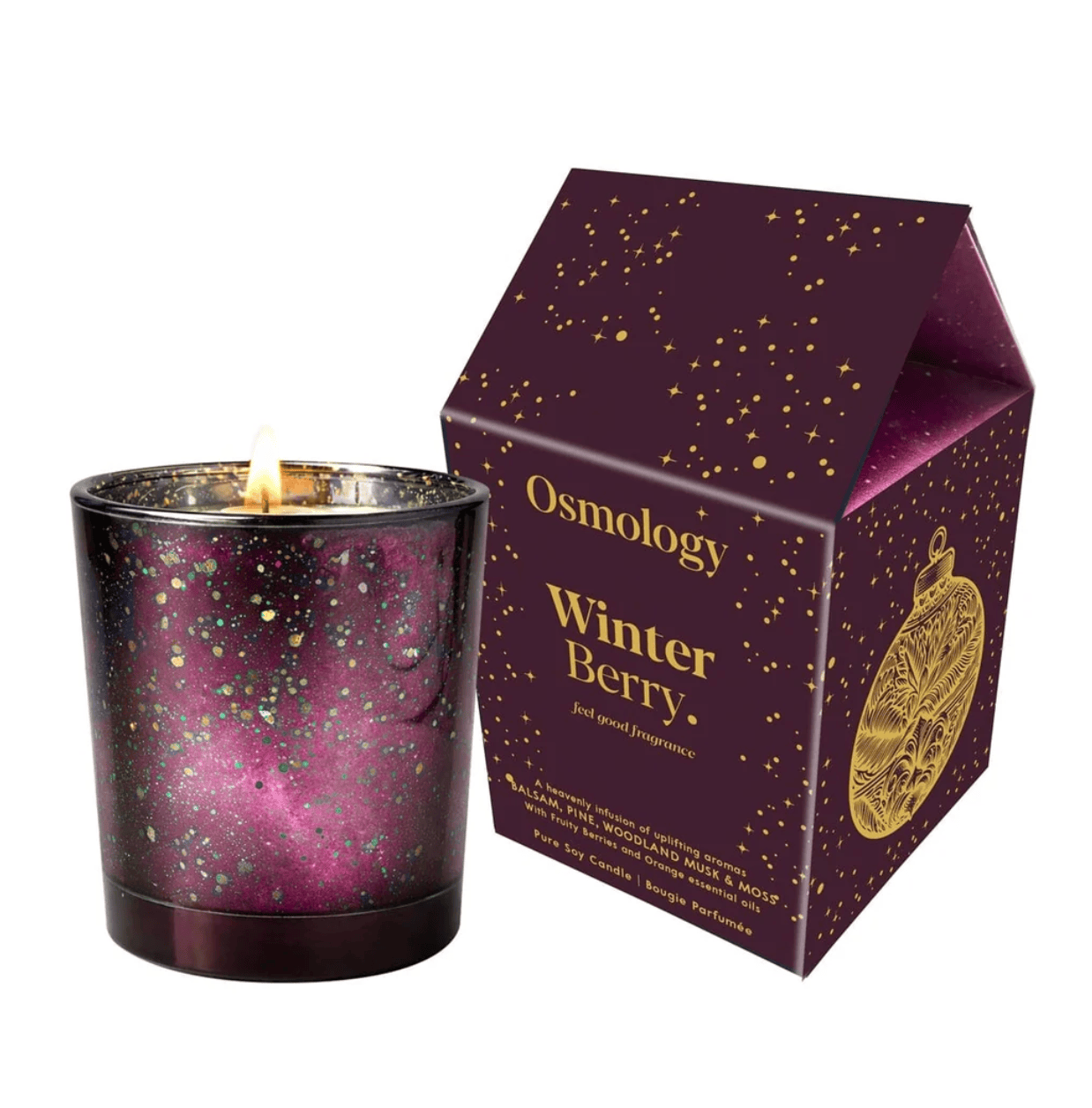 A lit Osmology Winter Berry scented candle in a dark purple glass jar with iridescent glitter, shown next to its matching dark purple and gold retail box on a white background.
