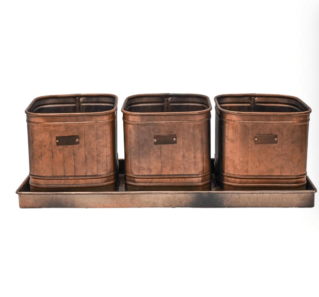 Set of three copper-colored metal planters on a matching tray with a white background