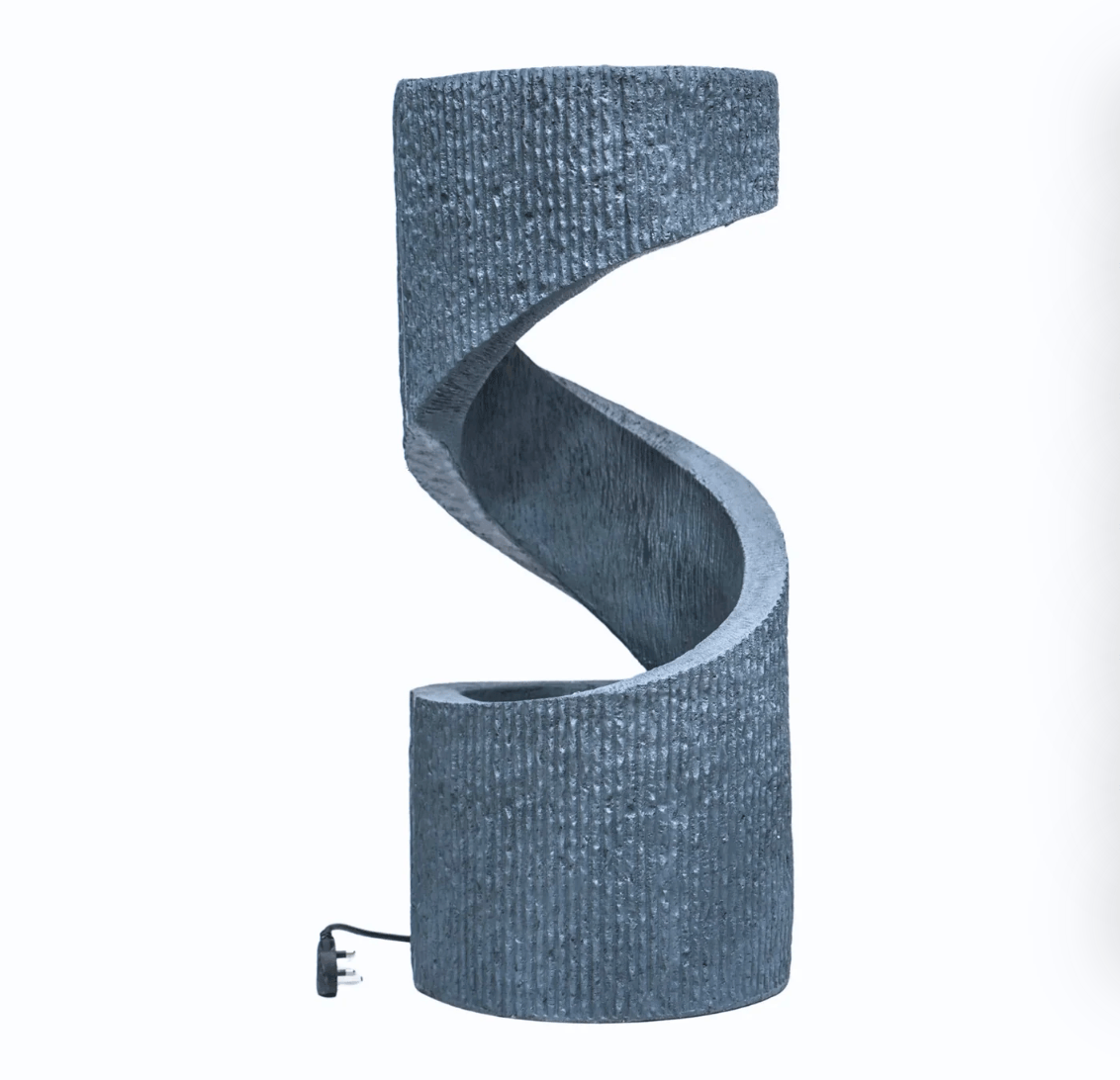 A modern spiral-shaped table lamp with a textured, ribbed fabric-like finish in a slate blue-gray color, shown on a plain white background with its power cord visible at the base.