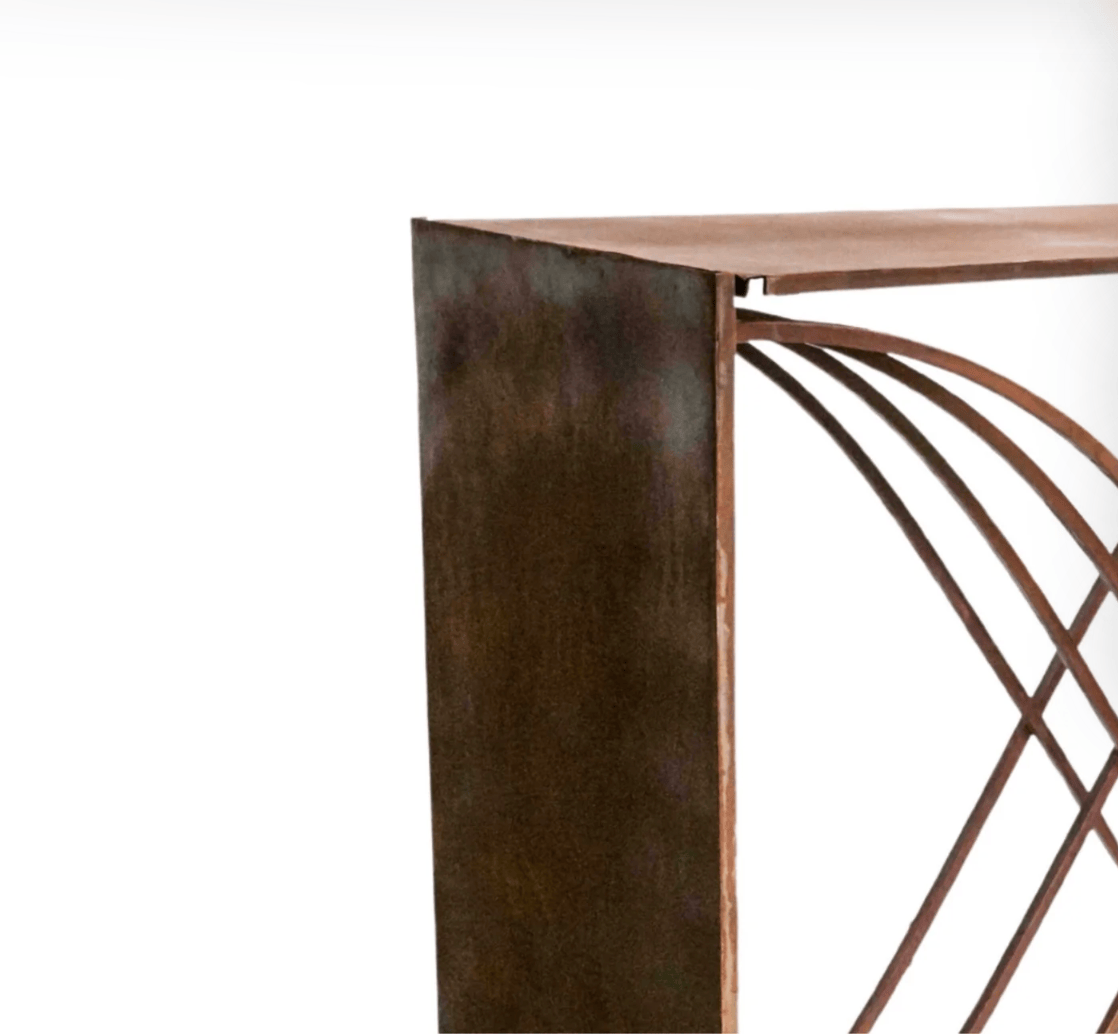 Close-up of a metal console table with decorative leg design on a white background