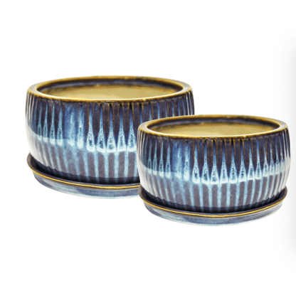 Two ceramic pots with blue and white striped design on a white background