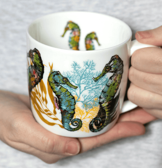 Person holding a mug with seahorse design