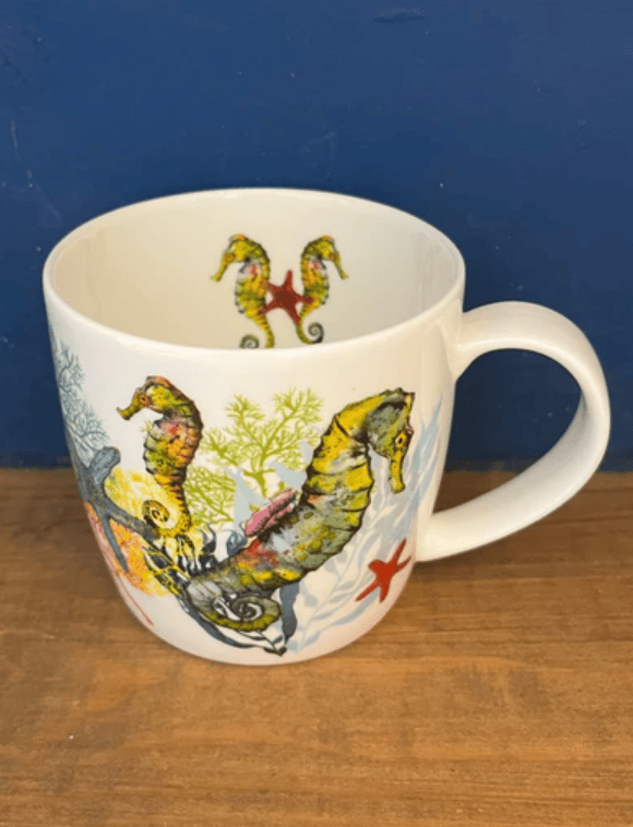 Mug with seahorse design on a wooden surface and blue background