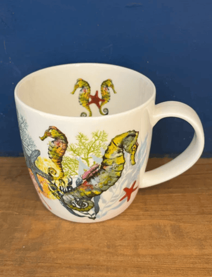 Mug with seahorse design on a wooden surface and blue background