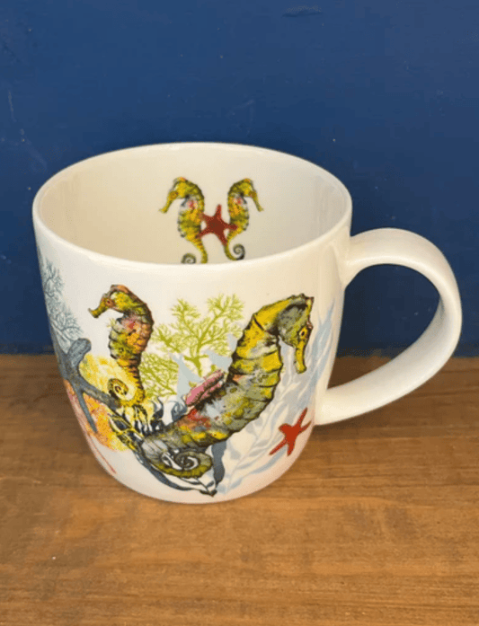 Mug with seahorse design on a wooden surface and blue background