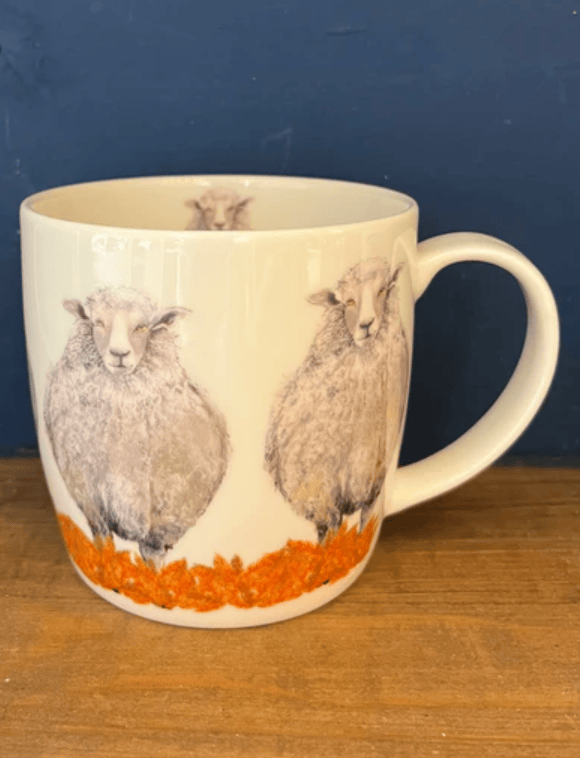 Mug with sheep design on a wooden surface and blue background