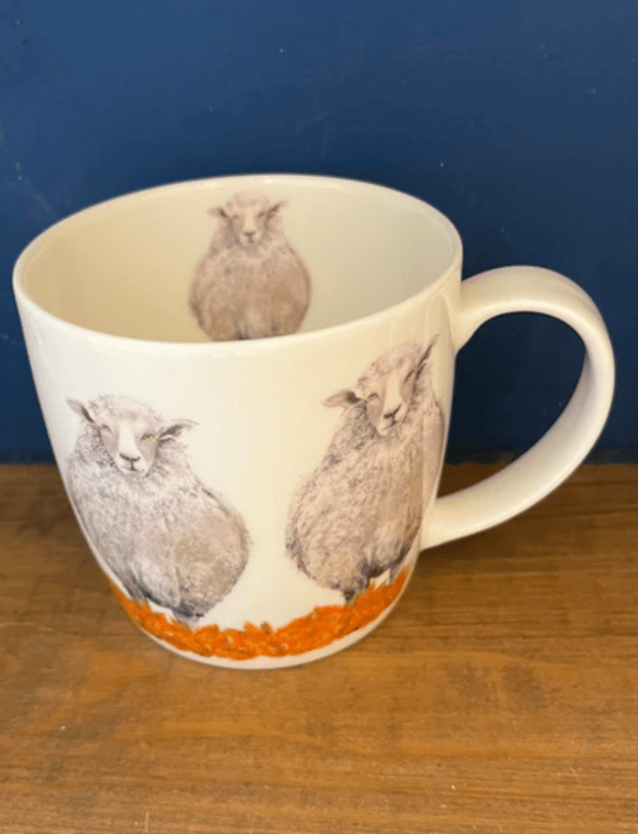 Mug with sheep design on a wooden surface and blue background