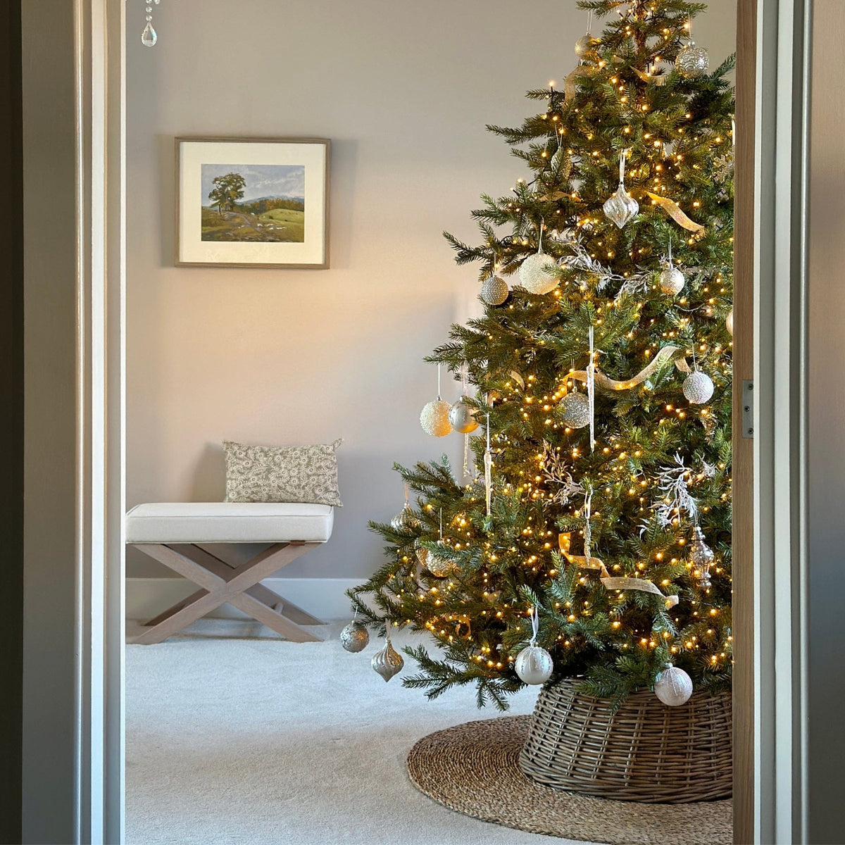 Christmas Tree decorated in white and gold decorations, adorned with an Ivyline Wicker Tree Skirt and Seagrass Tree Matt.
