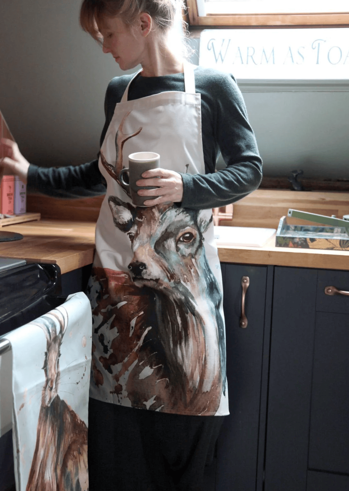 Person wearing a wolf-themed apron in a kitchen setting