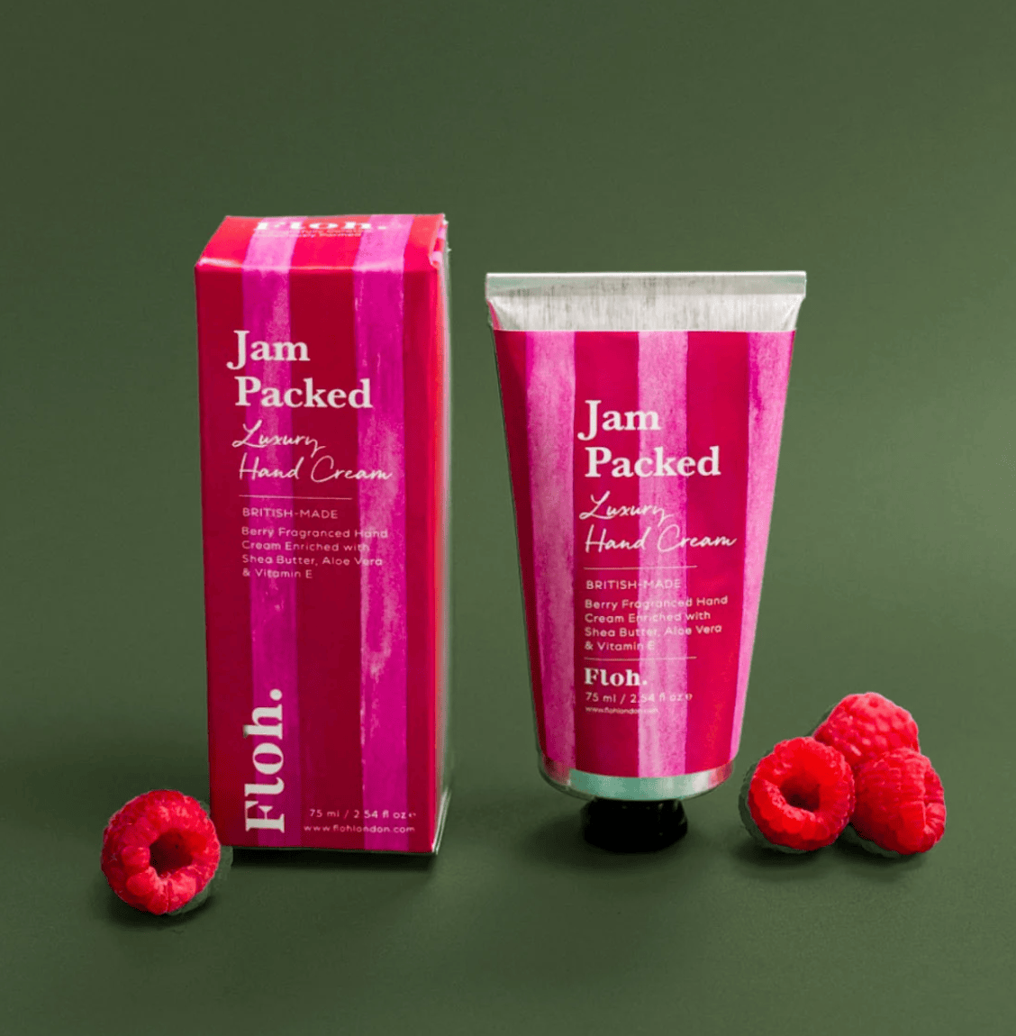 Jam Packed Luxury Hand Cream with packaging and raspberries on a green background