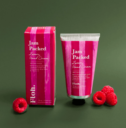 Jam Packed Luxury Hand Cream with packaging and raspberries on a green background