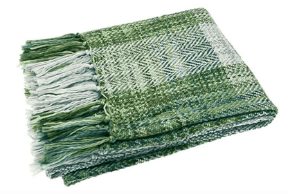 Green and white woven blanket with fringes on a white background